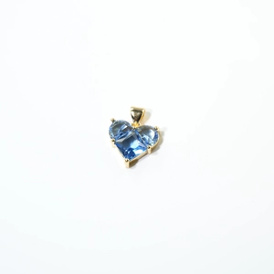 Détail du pendentif cœur en cristal bleu facetté avec serti à griffes dorées