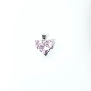 Macro detail of heart-shaped pink zircon pendant with silver-plated three-prong setting