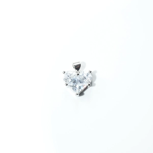 Detailed view of a silver heart-shaped pendant with a large clear heart-cut crystal
