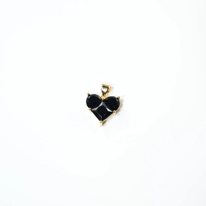 Détail du pendentif en cœur avec trois pierres noires taillées et serti doré