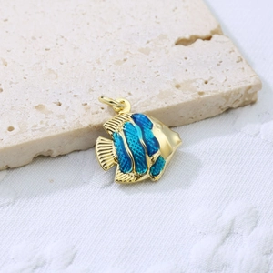 Macro shot of tropical fish pendant with blue enamel and gold-plated scales texture