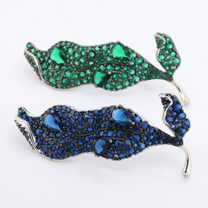 Détail de broches en forme de feuille avec zircons vert émeraude et bleu marine sur argent