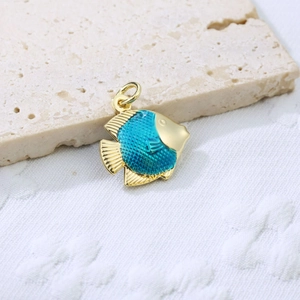 Macro detail of a fish-shaped pendant with gold edges and vibrant turquoise enamel