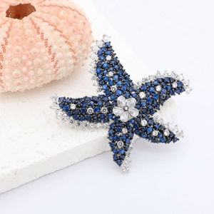 Starfish brooch with blue and white pavé cubic zirconia set on a textured white stone