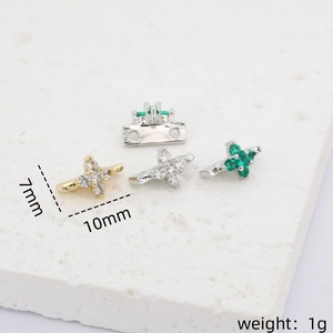Macro view of 14k gold plated star spacer beads with inlaid green and white zircons