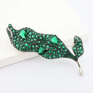 Broche élégante en argent en forme de feuille avec zircons verts sur marbre
