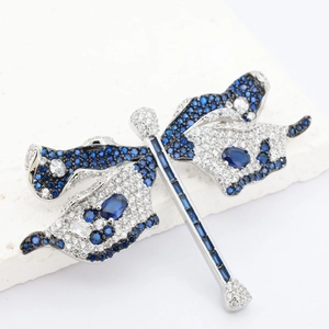 Elegant dragonfly brooch with blue crystals and silver finish on white stone