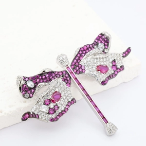 Macro detail of luxury dragonfly brooch with pink and white gemstones on marble