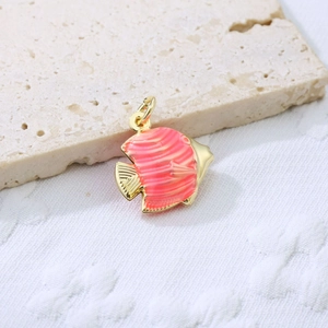 Detail of coral pink enamel tropical fish pendant with wavy stripes on gold base