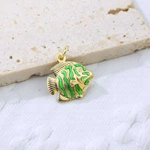 Detailed close-up of fish pendant with green enamel stripes on gold plated copper
