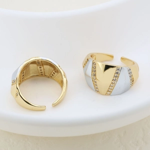 Detail of two-tone adjustable rings with micro-inlaid stones on a ceramic plate