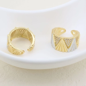 Detailed view of two-tone adjustable rings with geometric relief and pavé set zircons