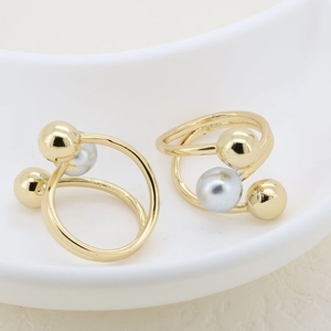 Detail of double-layer gold spiral rings featuring grey pearls and polished golden beads