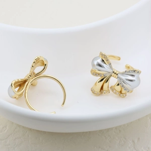 Detail of elegant two-tone 18K gold plated bow ring with sparkling zircon stones