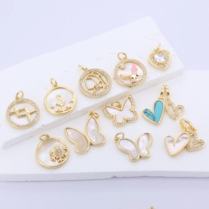 Gold plated butterfly and animal shell pendants with zircon inlay on stone pedestal