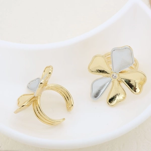 Detailed view of two-tone clover ring with sparkling center zircon and open band