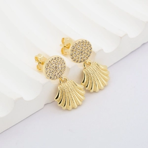 Makroansicht goldener Muschelohrringe mit Zirkonia-Besatz und detaillierter Metalltextur