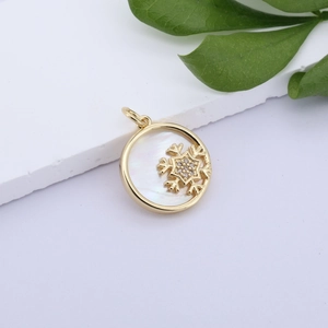 Macro view of gold plated snowflake pendant with mother of pearl and zircon stones