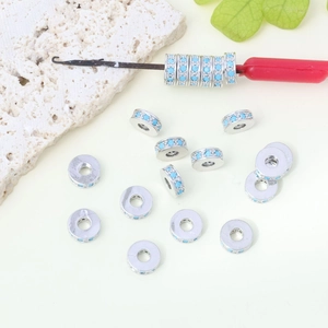 Dettaglio di perle distanziatrici in argento con zirconi turchesi su attrezzo gioielli