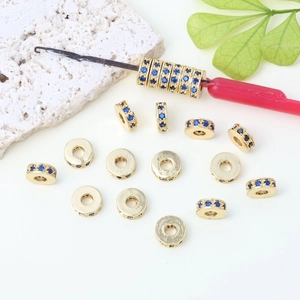 Dettaglio ravvicinato di un distanziatore placcato oro 14k con zirconi blu micro-incastonati