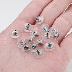 Chiusure per orecchini in rame con dischi stabilizzatori in plastica trasparente sulla mano