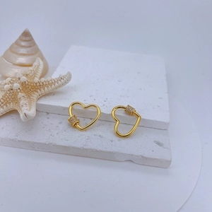 Macro shot of 18k gold plated heart screw clasps with zircon inlay on stone base