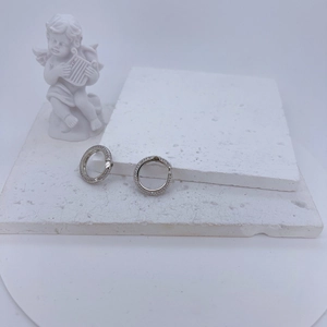 Elegant silver pave hoop earrings with clear cubic zirconia on minimalist stone background