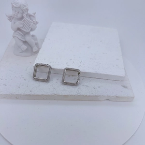 Micro-pave square silver hoop earrings with white crystals on a minimalist stone base