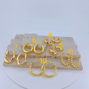 Collection of golden geometric and textured hoop earrings on stone display base