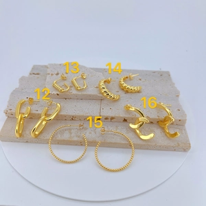 Detail of five different geometric gold earrings including chain link and twisted styles