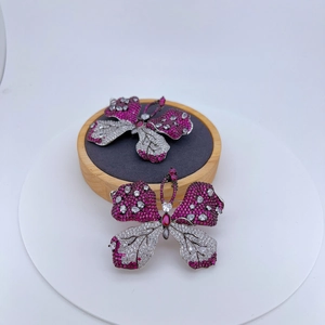 Eleganter Schmetterling-Anstecknadel mit roten und weißen Zirkonia auf Holzständer