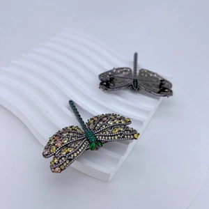 Macro detail of dragonfly brooch with colorful gems and secure pin closure