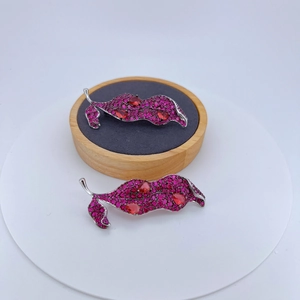 Elegant silver leaf brooch set with vibrant pink cubic zirconia and red pear-cut stones
