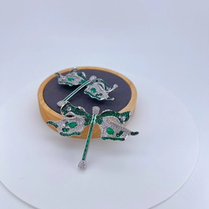 Broche libellule scintillante avec pierres vert émeraude et incrustation de zircone