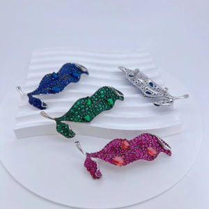 Detail showing multicolored zircon leaf brooches with secure pin clasp on wave stand