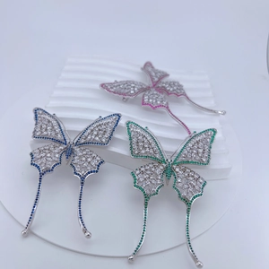 Macro view of crystal butterfly brooches with colorful zircon tassels and gold plating