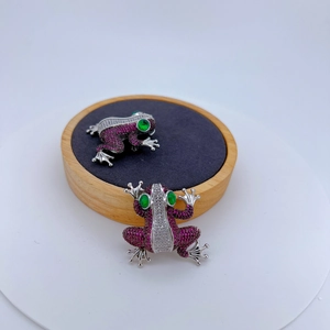 Intricate frog brooches with pink crystals and green gem eyes in a silver-toned setting