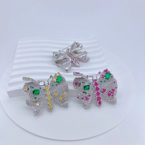Détail de la broche papillon avec pierres vertes et zircones cubiques pavées sur blanc