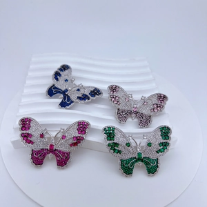 Macro shot of butterfly brooches with pavé zircon crystals in four vibrant colors