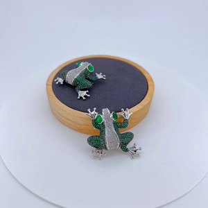 Micro-pave green and white cubic zirconia frog brooch with vivid emerald eyes and silver plating
