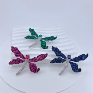 Detailed macro of crystal dragonfly brooches featuring colorful micro-pave cubic zirconia