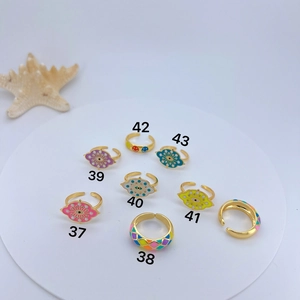 Flat lay of colorful enamel Evil Eye and smiley face gold-plated open rings on display