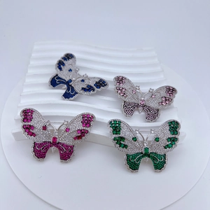 Detailed close-up of hollow butterfly brooches with micro-pave cubic zirconia and gemstones