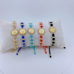 Details bunter gewebter religiöser Armbänder mit goldenen Jesus-Medaillen und Zirkonia