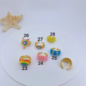 Detail of adjustable evil eye and rainbow enamel rings with gold plated finish