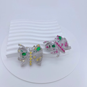 Détail des broches papillon en cristal avec pierres colorées sur blocs blancs texturés
