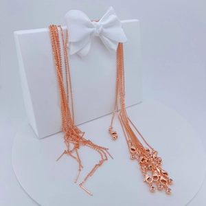 Detalle de cadenas cruzadas de oro rosa con cierre de mosquetón para joyería artesanal