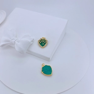 Detail of shield-shaped malachite pendants with 18K gold plating and zircon star inlay