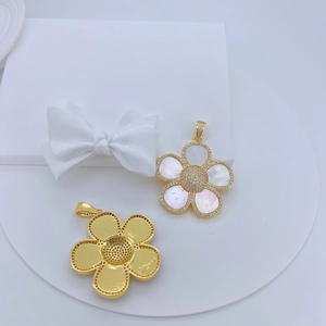 Detail eines 18K Goldblumenanhängers mit weißer Perlmuttmuschel und Zirkonia-Pavé