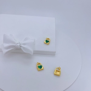 Pendentif cadenas cœur plaqué or 18K avec pierre verte sur fond de soie blanche